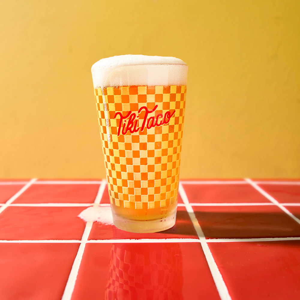 Draft Beer in a branded checkered board tiki taco glass