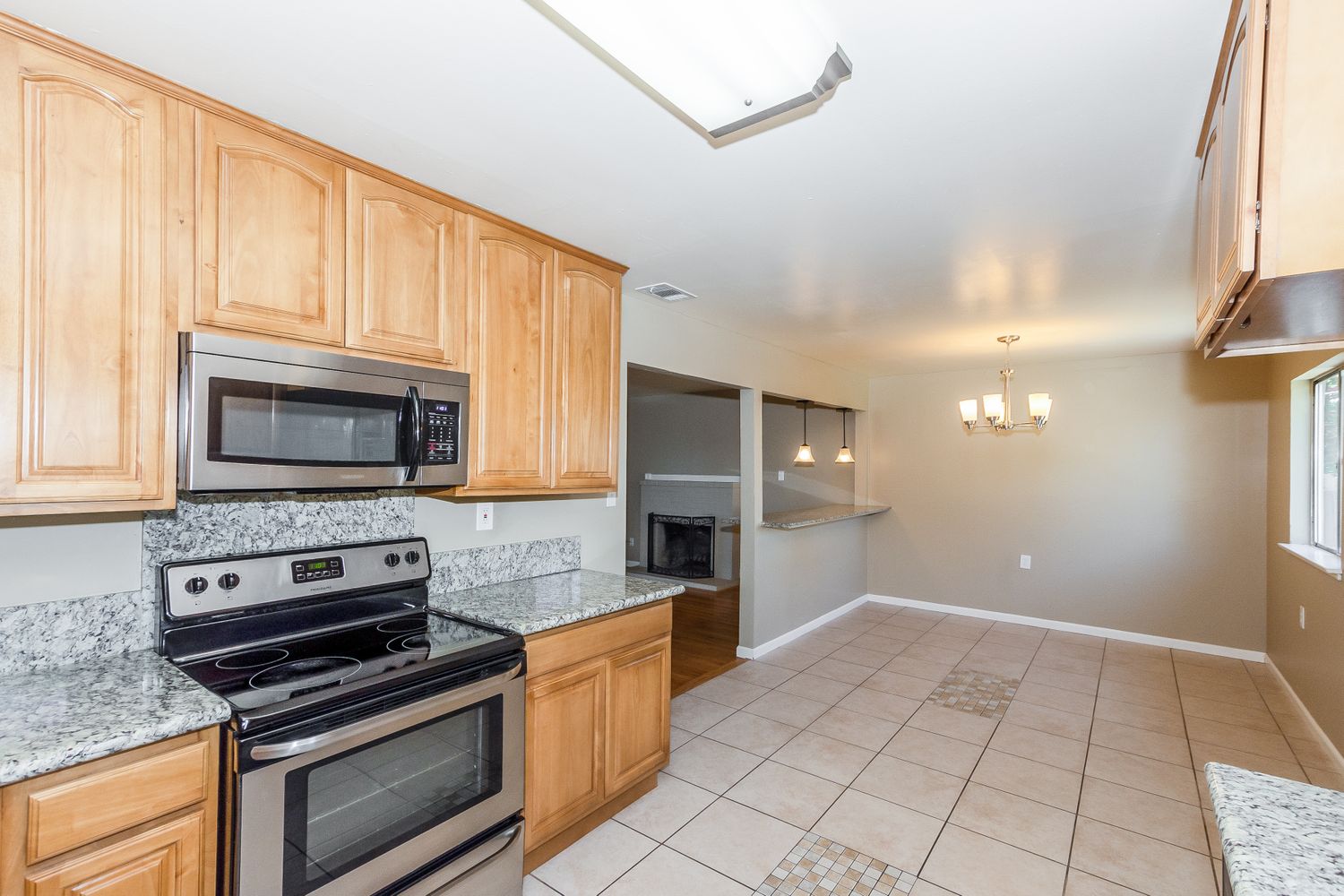 Kitchen with granite countertops, stainless-steel appliances and tile flooring at Invitation Homes Northern CA.