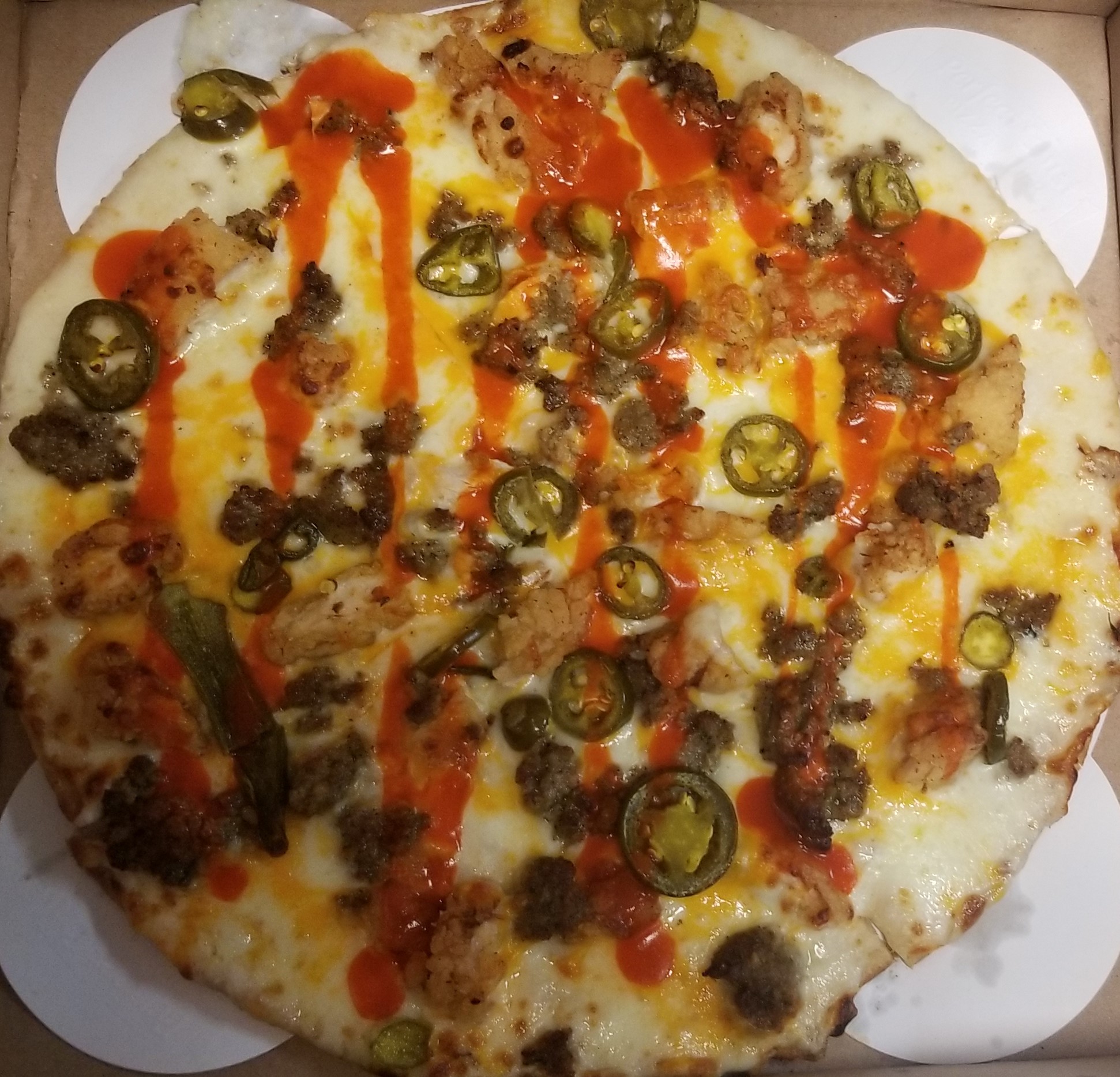 Fan Creation! Alfredo Sauce base with jalapenos, beef, fried chicken, cheddar cheese and buffalo drizzel on top!