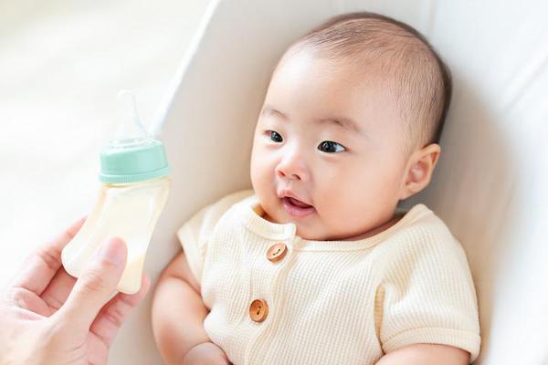 赤ちゃんにミルクを飲ませようとしている様子