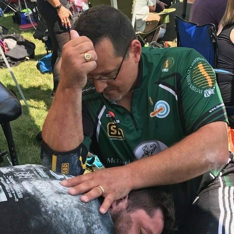 Dr. McDougle performing a cost correction on one of the athletes in the Michigan strongest man competition.