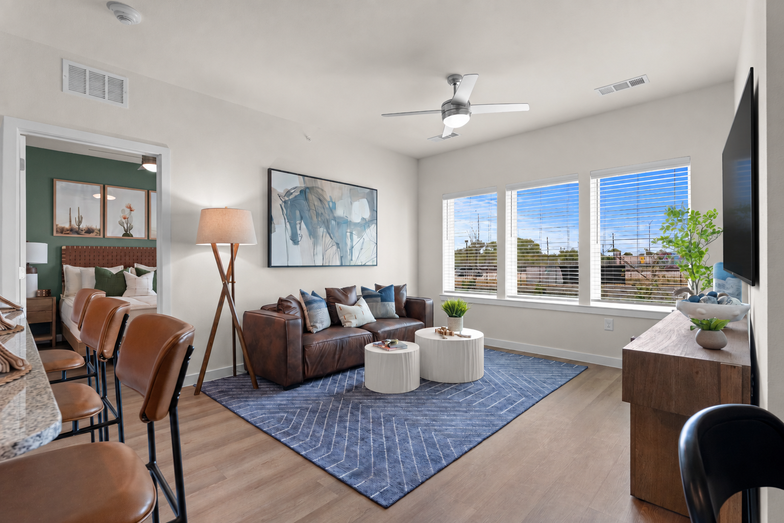 Living room, eat up bar and view in to bedroom of a two bedroom model at Cyrus Apartments 