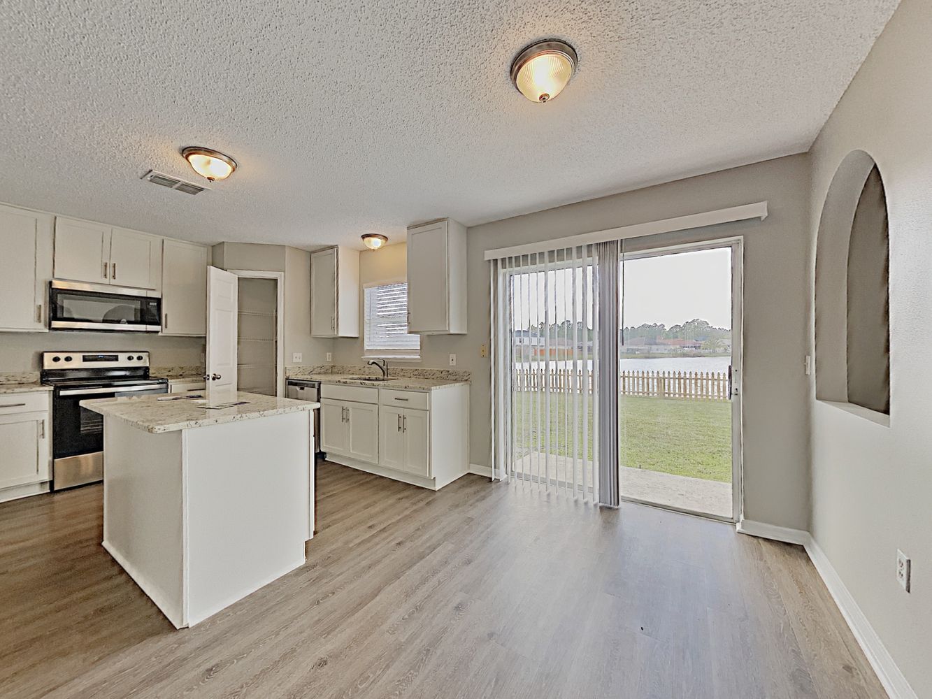 Modern kitchen with stainless steel appliances and an island at Invitation Homes Jacksonville.