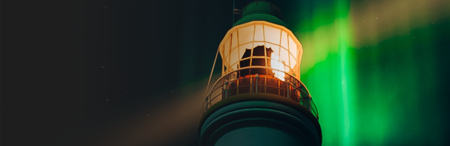 A lighthouse shining in front of green light of the aurora borealis.