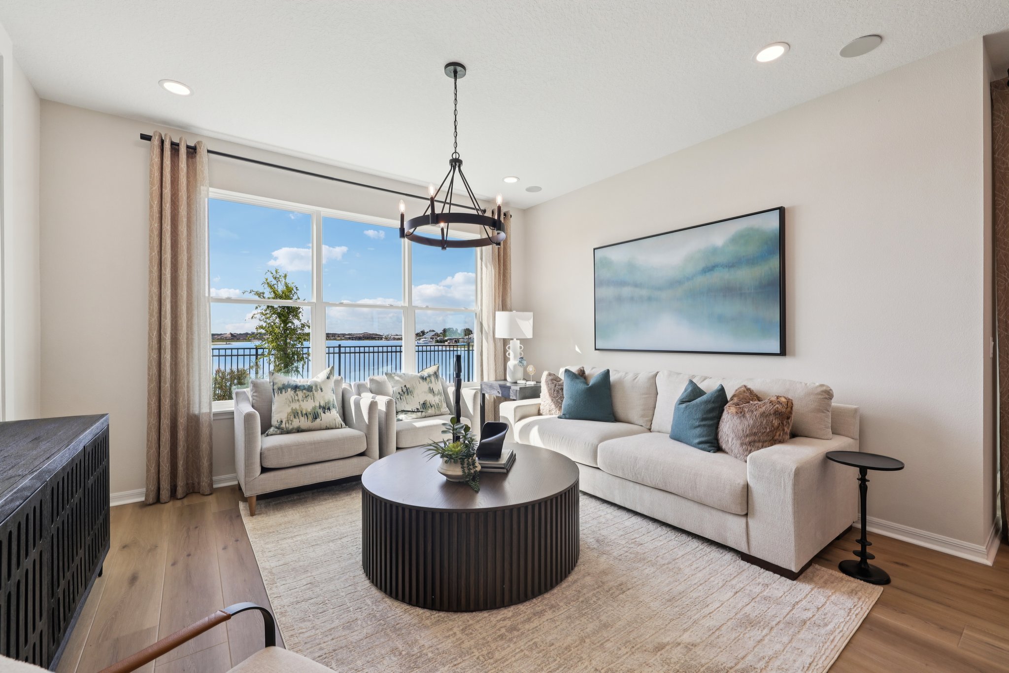 The Living Room with Mirada Lagoon Views of a DRB Homes Aruba Model at Isla Mirada in San Antonio, F 