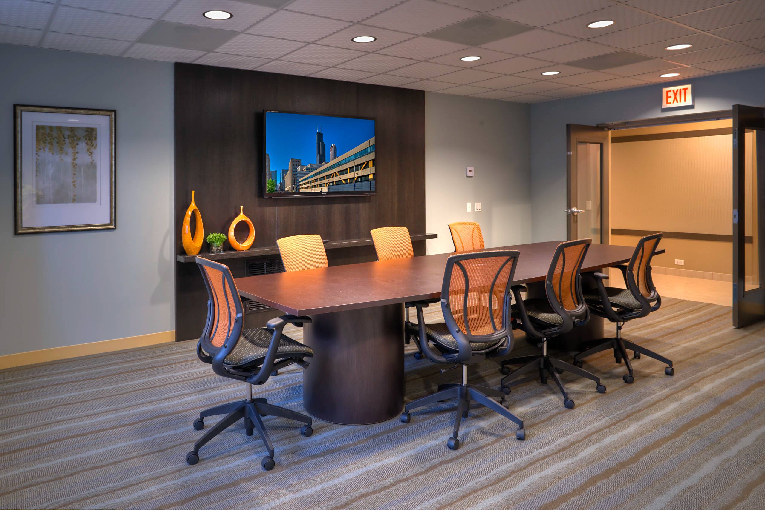 Conference room with meeting table and orange chairs 