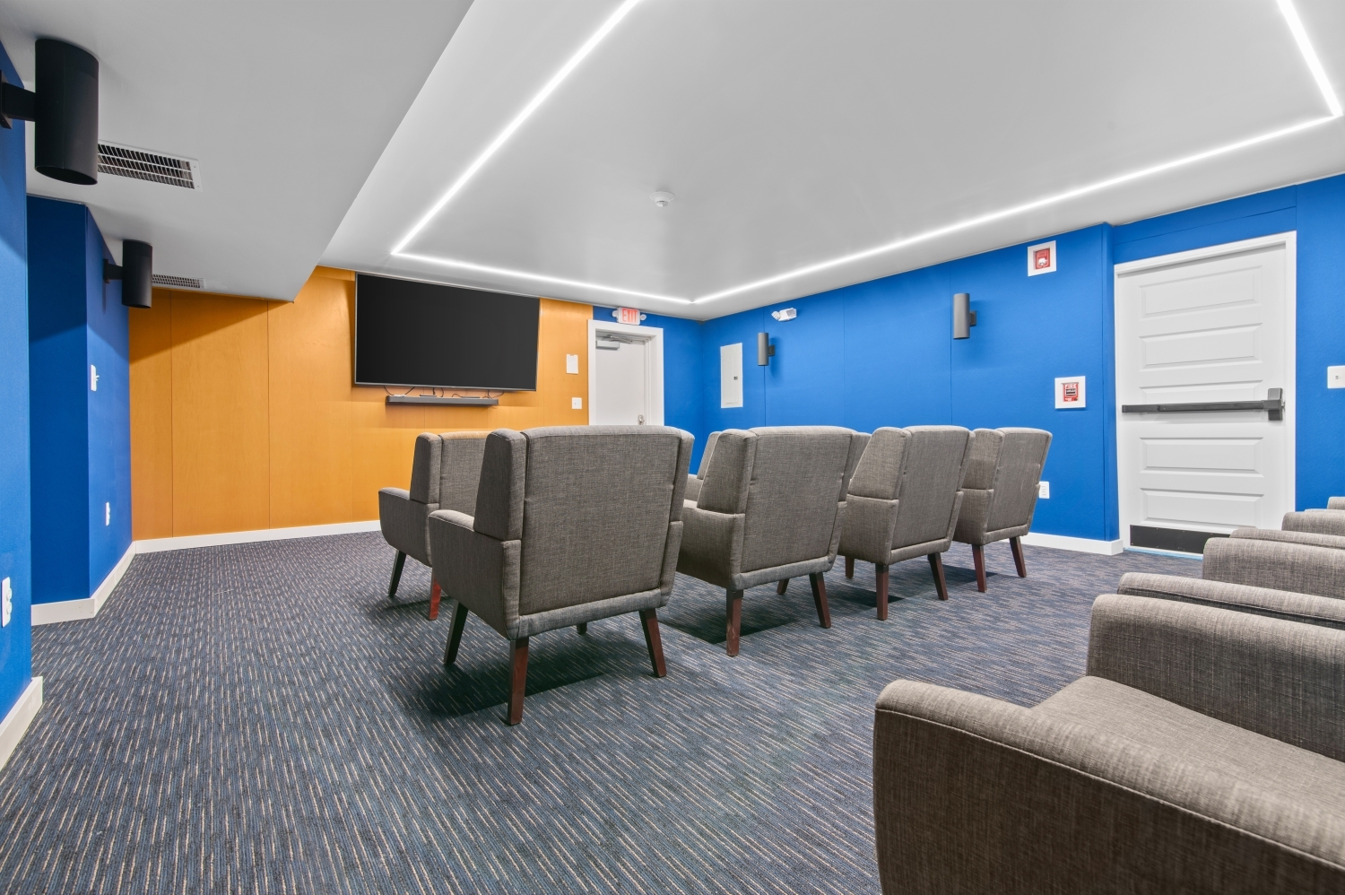 This image features the resident theater and entertainment room at Solaire Senior Living in Southfield, MI, providing a comfortable space where residents 62 years of age and better can relax and enjoy movies, presentations, and community gatherings. The modern seating, large screen display, and inviting atmosphere create a perfect setting for social entertainment and shared experiences. As part of this luxury senior apartment community, spaces like this help residents stay engaged while enjoying the peaceful lifestyle Solaire offers.