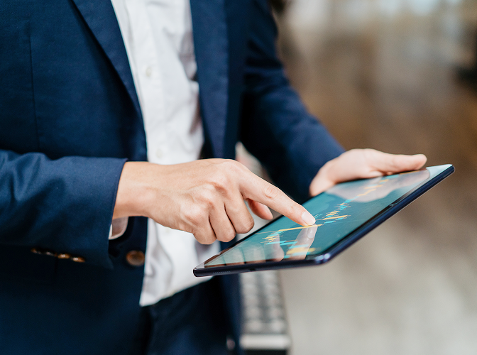 Close-up of a person looking at a graph on their tablet.