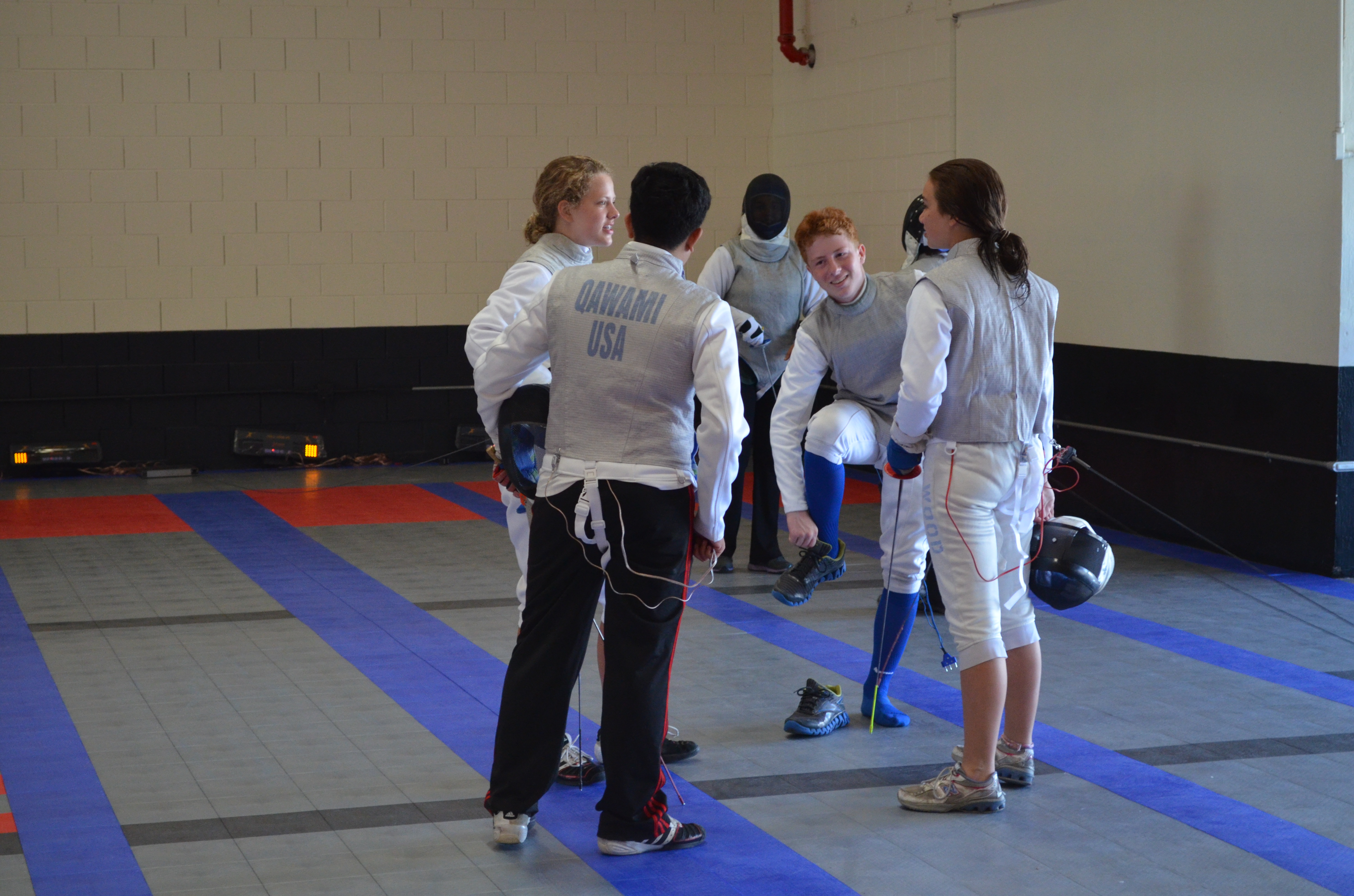 Fencers discuss a foil fencing bout at Academy of Fencing Masters