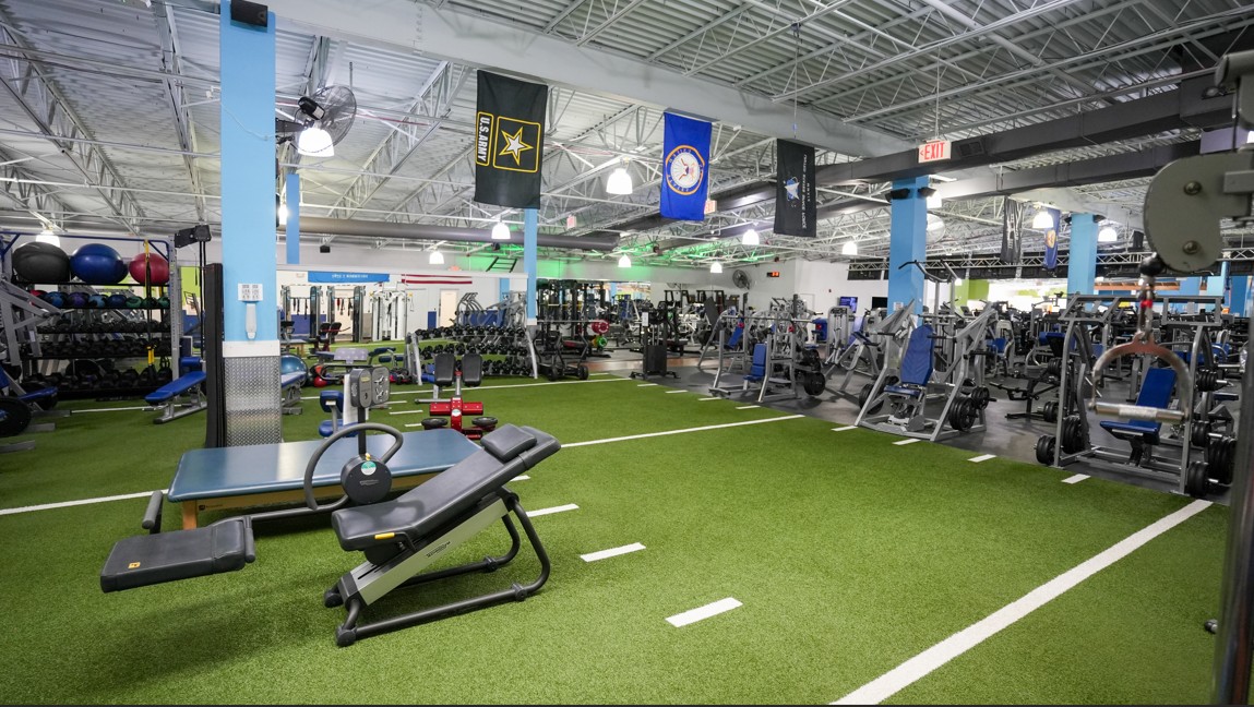 Strength and turf integration area at Everyone Fitness Rehoboth Beach with benches, dumbbells, and open space for movement.
