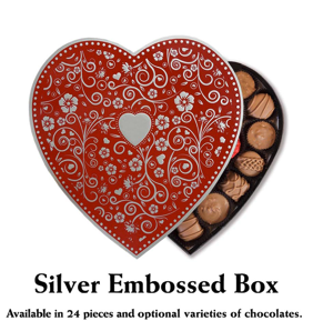 A beautifully designed heart-shaped box of chocolates from Florence's Exquisite Chocolates in Rexburg, ID. The "Silver Embossed Box" features an elegant red and silver floral design with a central heart accent. Inside, an assortment of chocolates—including milk, dark, and mixed varieties—are arranged, making it a perfect gift for Valentine's Day. This premium packaging, available in 24 pieces with optional varieties, highlights Florence's dedication to quality and presentation.