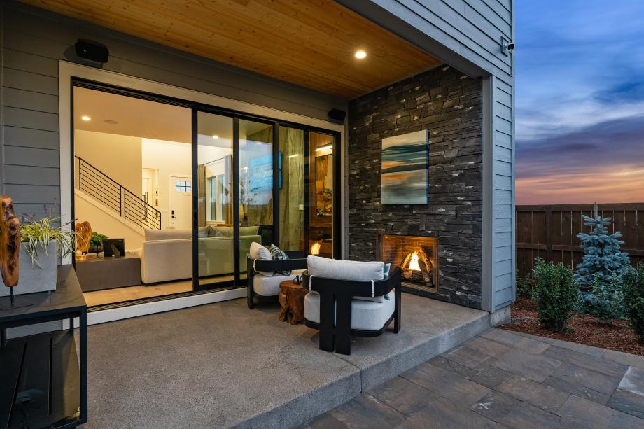 Enjoy seamless indoor-outdoor living through stacking glass doors to a covered patio with a fireplace