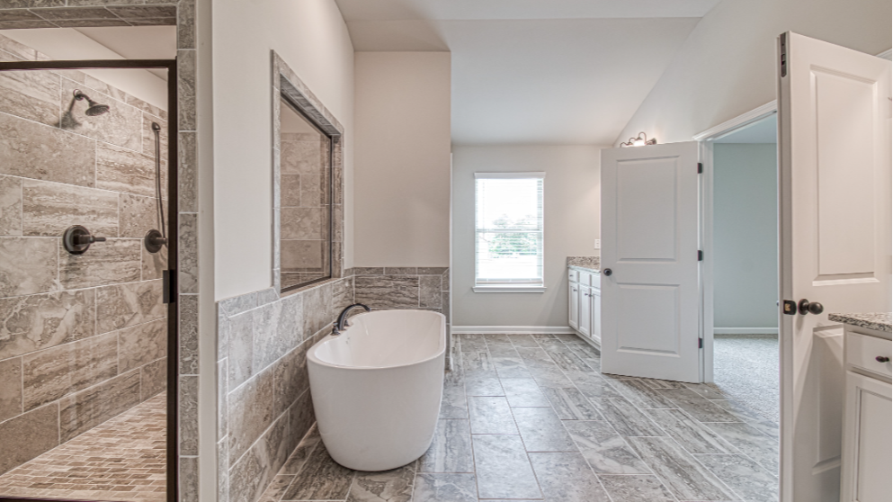 Owners' bathroom with soaking tub and shower at DRB Homes Luella Grove Community