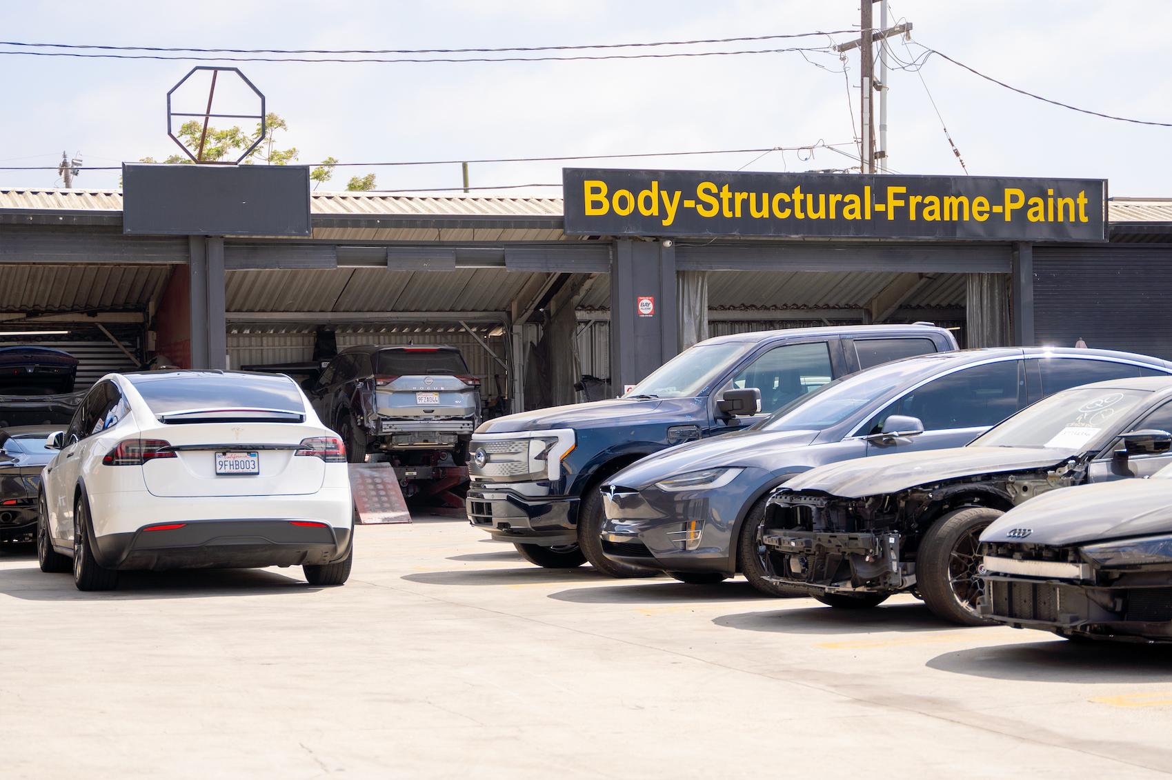 Line up of cars waiting for collision repair at LUXE Auto Body Shop