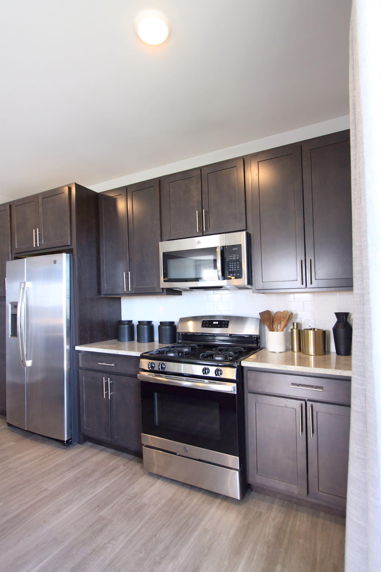 A kitchen with dark cabinets and stainless steel appliances