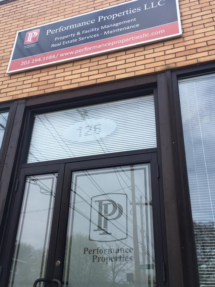 Performance Properties LLC office entrance featuring branded signage, glass doors, and professional exterior design. The storefront highlights property management, facility maintenance, and real estate services while presenting a clean, modern business appearance focused on reliability, customer service, and commercial property solutions.