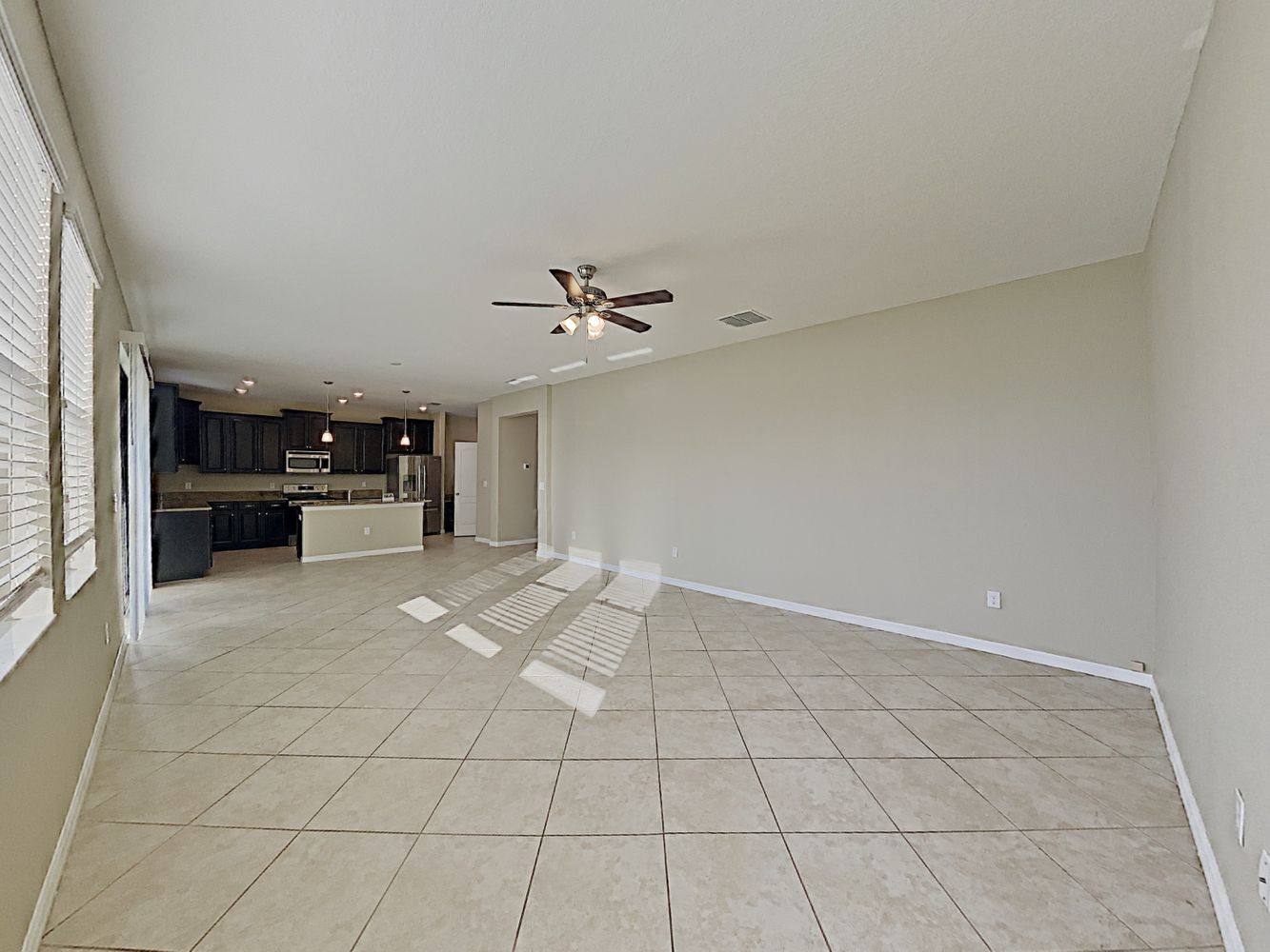 Spacious living room with easy access to modern kitchen at Invitation Homes Tampa.