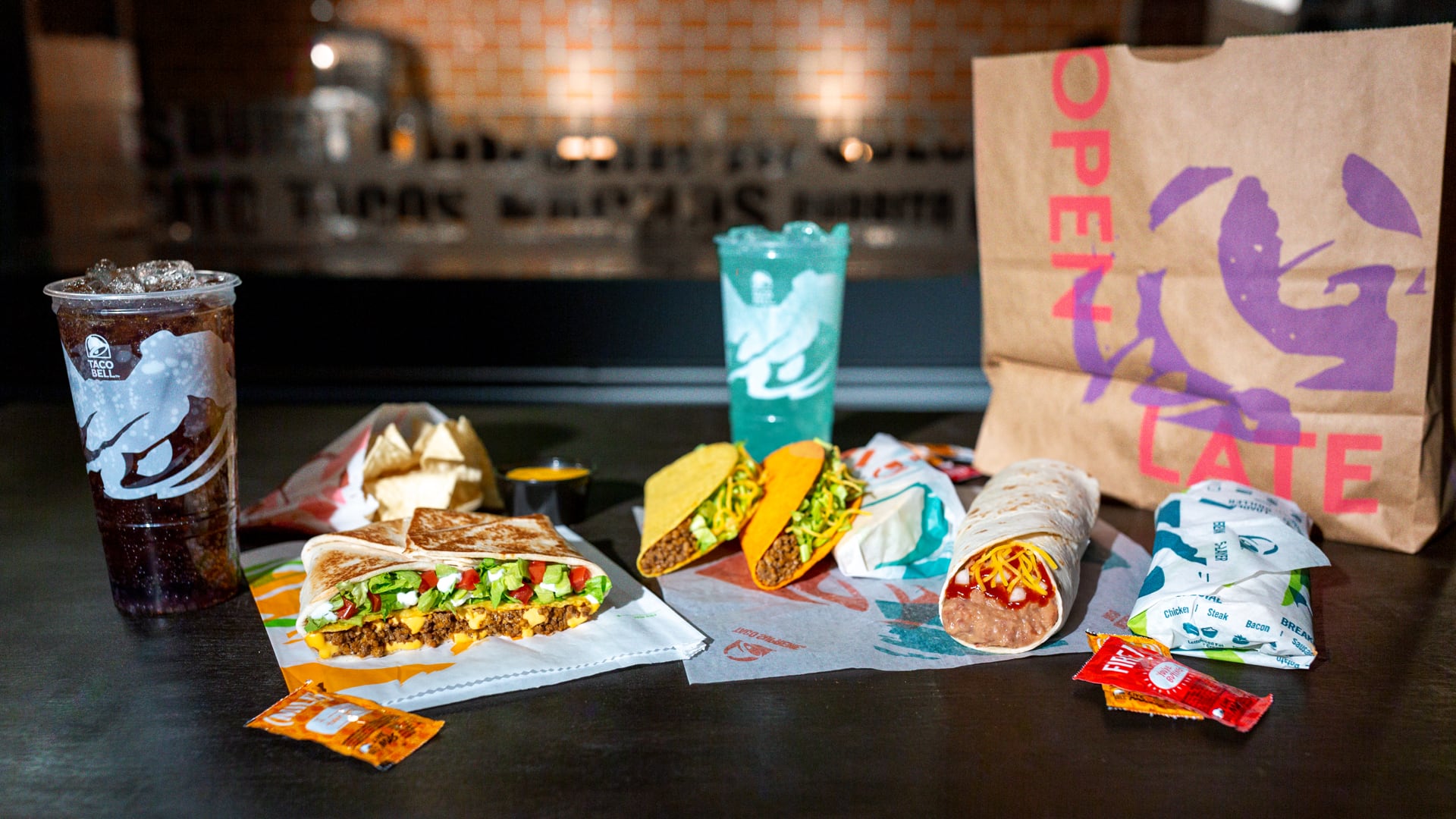 An arrangement of a Taco Bell Order including 1 Crunchy Taco, 1 Doritos® Loco Taco, 1 burrito, a couple of wrapped soft tacos and 1 Crunchwrap Supreme®.