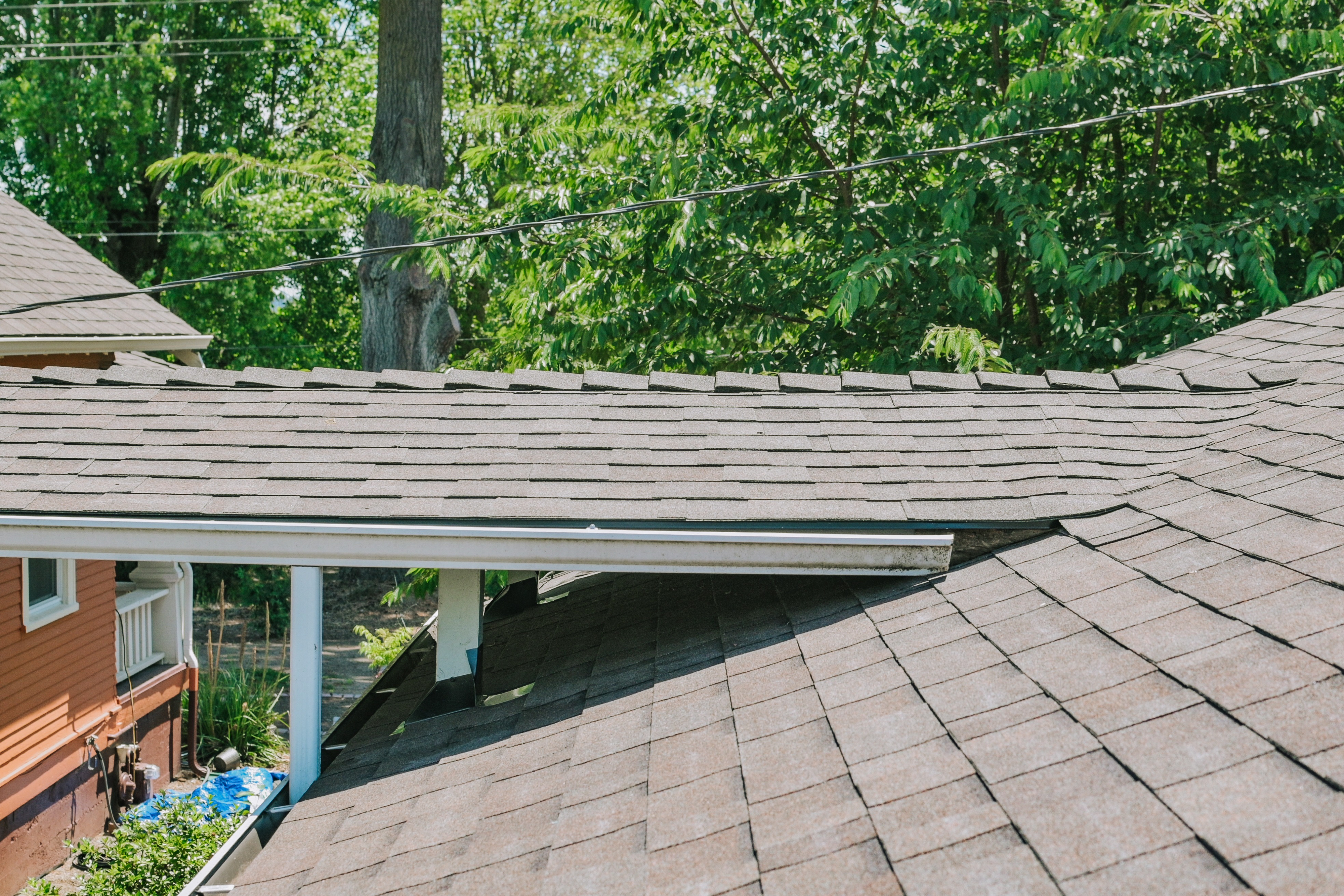 Residential asphalt shingle roof showing multiple roof sections and intersecting rooflines. 