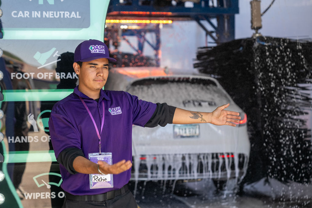 DASH Car Wash team member guiding a customer safely into the wash tunnel. 