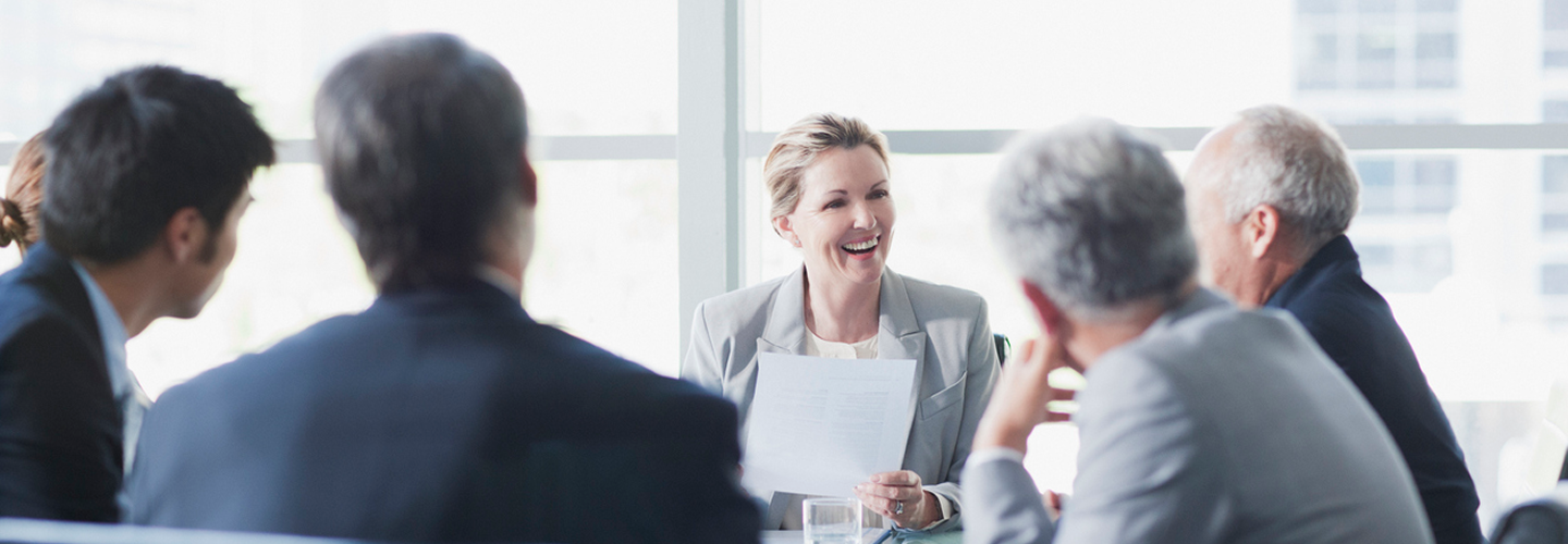 Professionals working around a boardroom table.