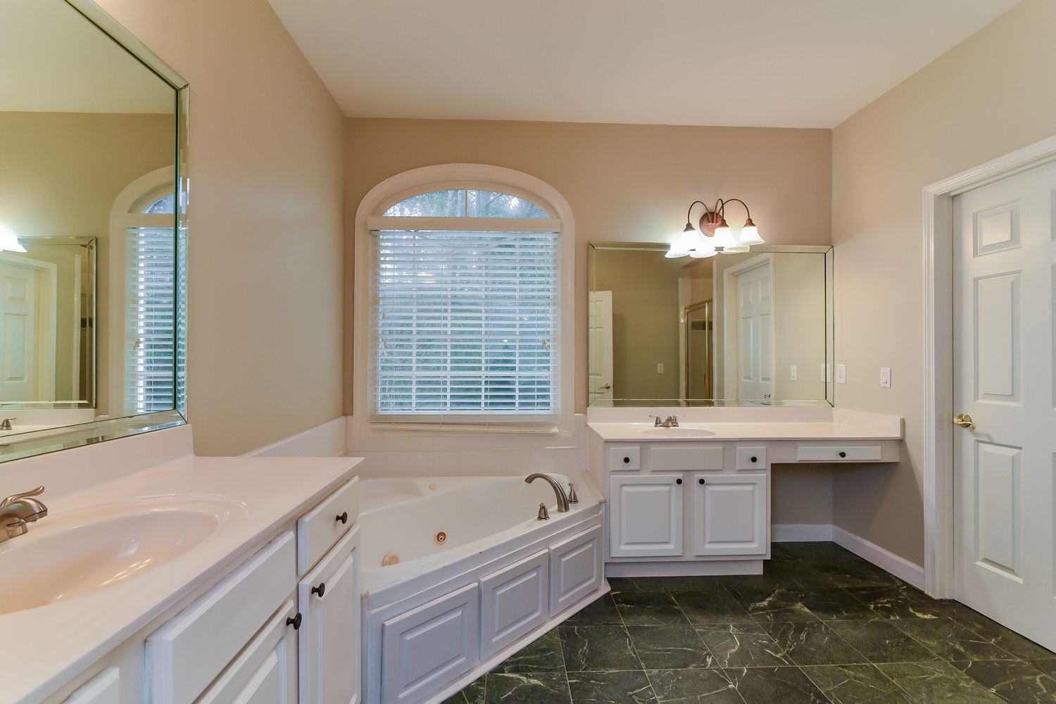 Spacious bathroom with relaxing tub and vanity area at Invitation Homes Atlanta.