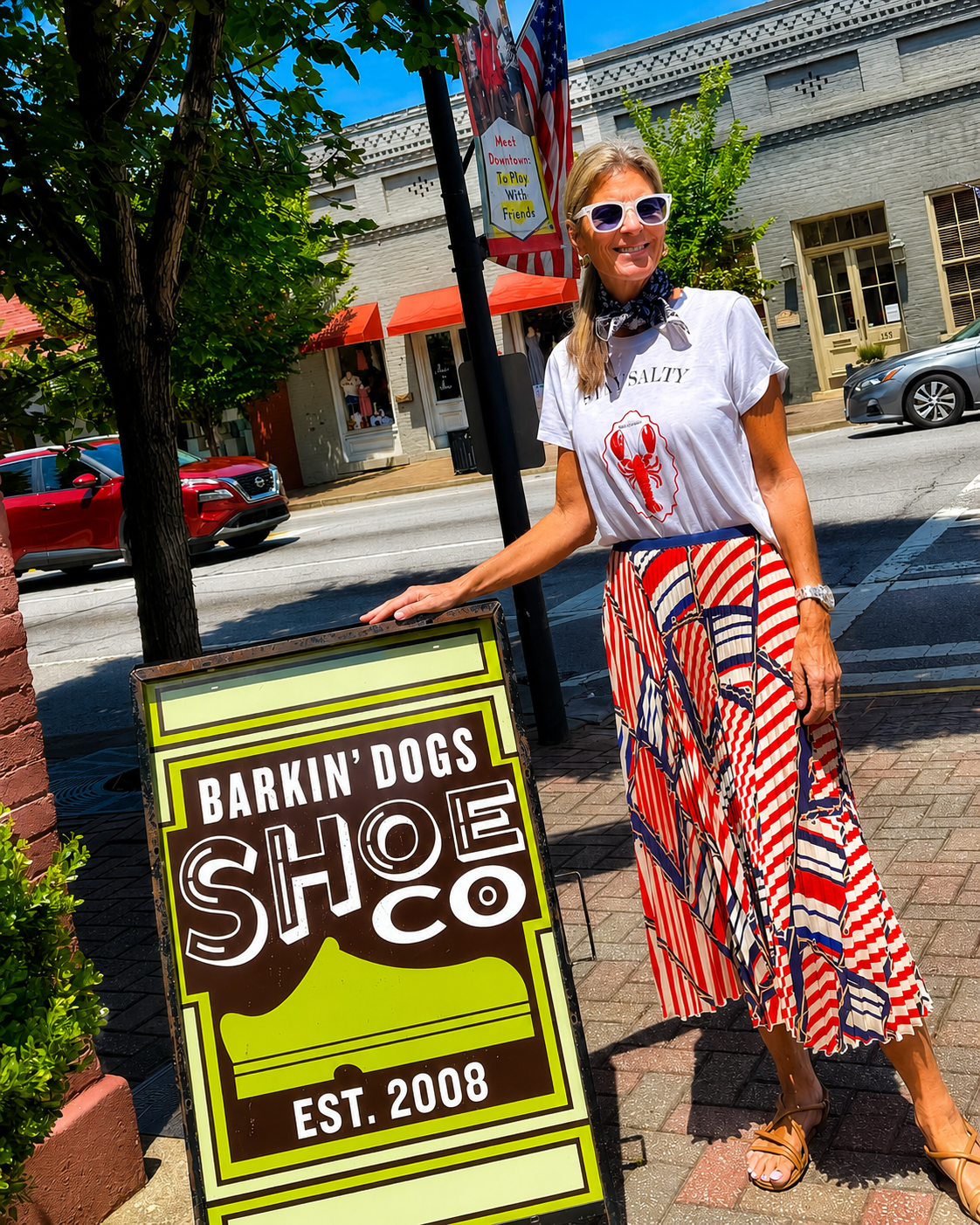 Customer enjoying a stylish shopping experience outside Barkin' Dogs Shoe Co. in a vibrant downtown setting. Featuring boutique fashion, footwear, and accessories that reflect everyday style and comfort.
