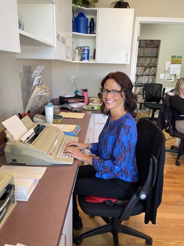 Kerry sitting at the front desk of Marshall Family Chiropractic