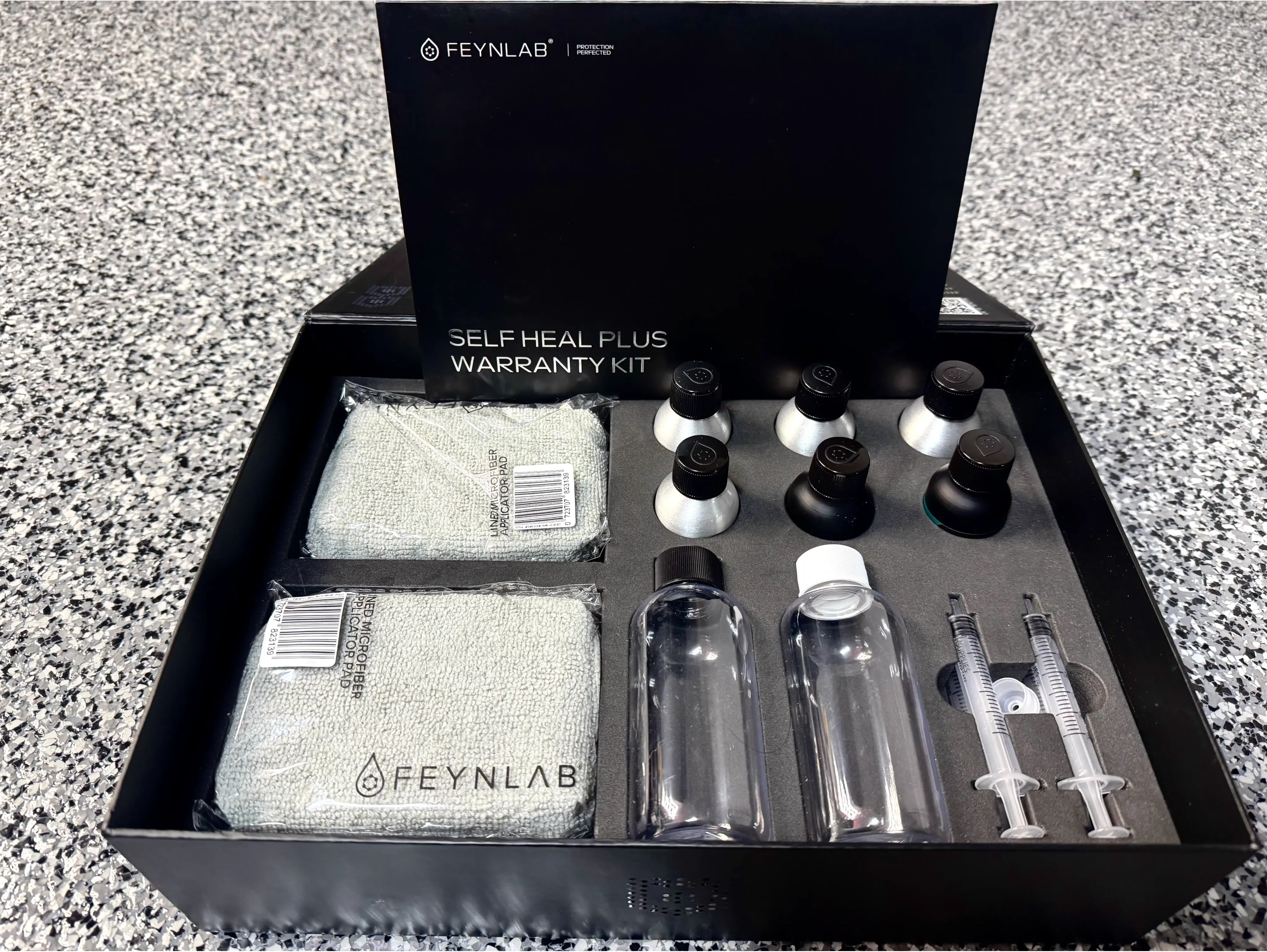 Inside the FEYNLAB Self-Healing Ceramic Coating warranty kit — professional-grade application tools  
