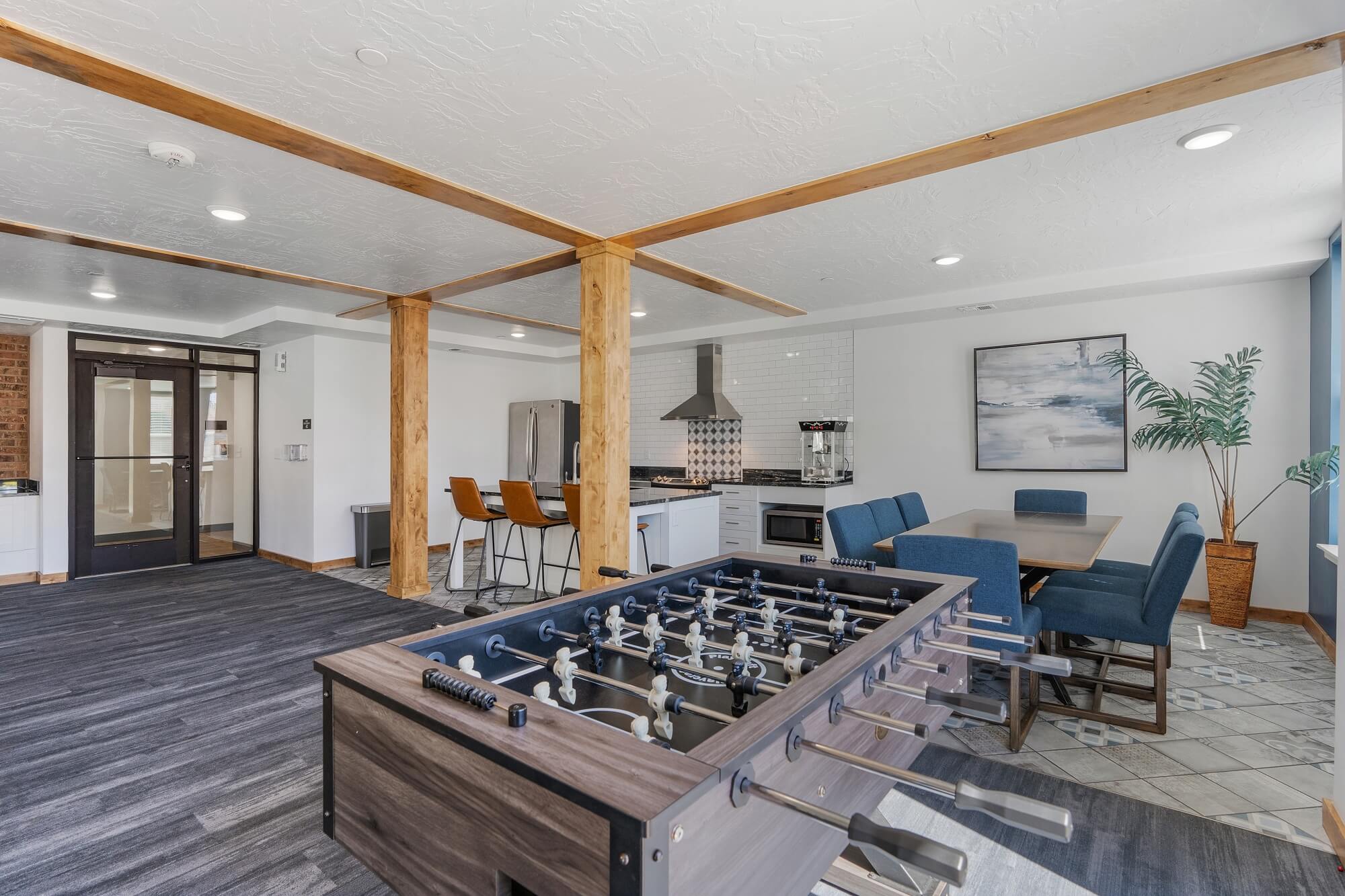 a family room with a foosball table and a kitchen with a dining area