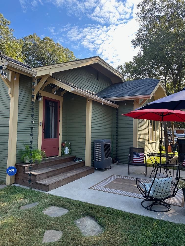 Exterior home remodeling project featuring a green-sided house, updated entryway, wooden steps, cove 