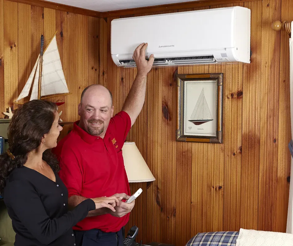 Robies employee talking with female customer in home with mini split and remote
