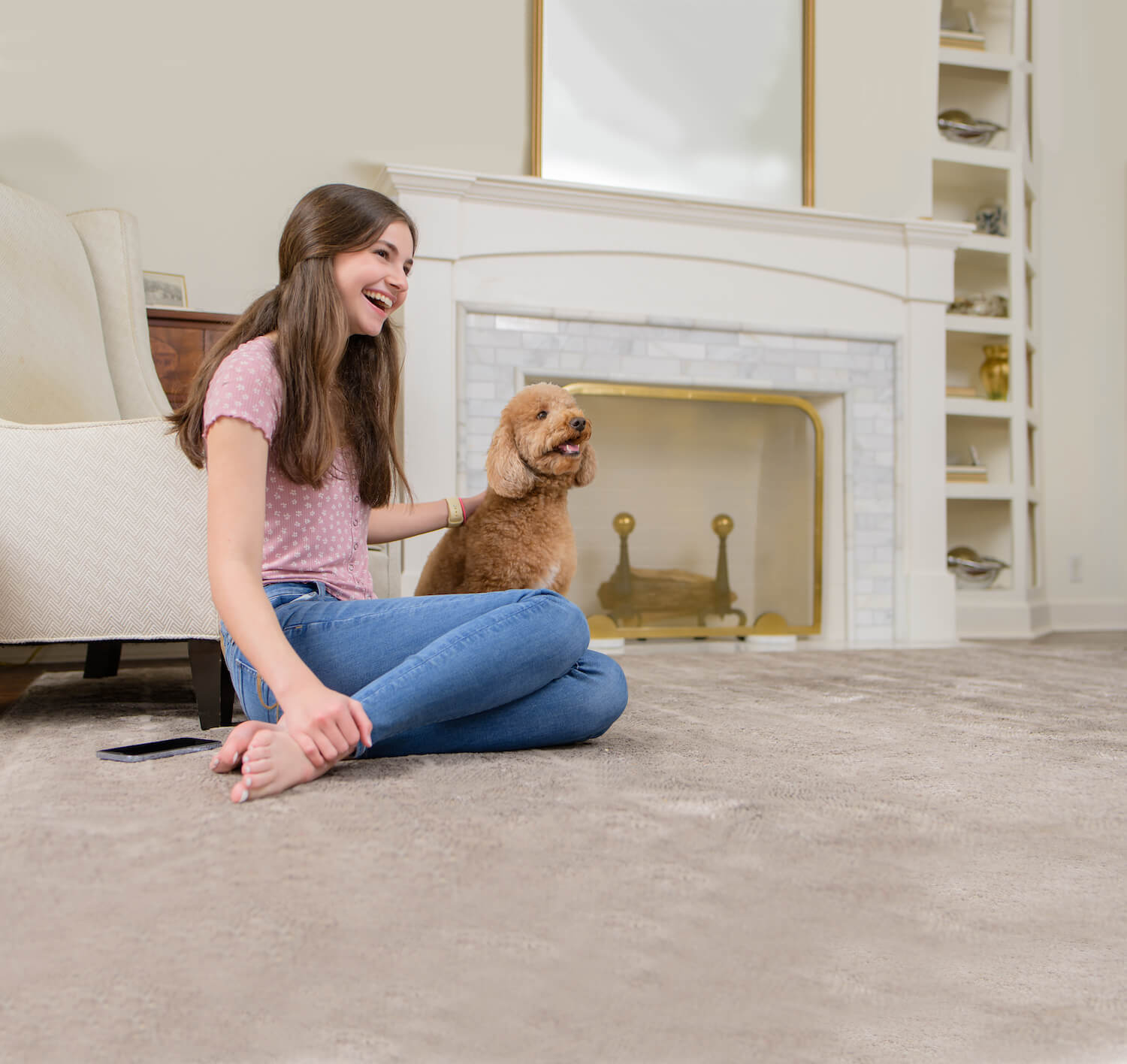 girl sitting on carpet with dog