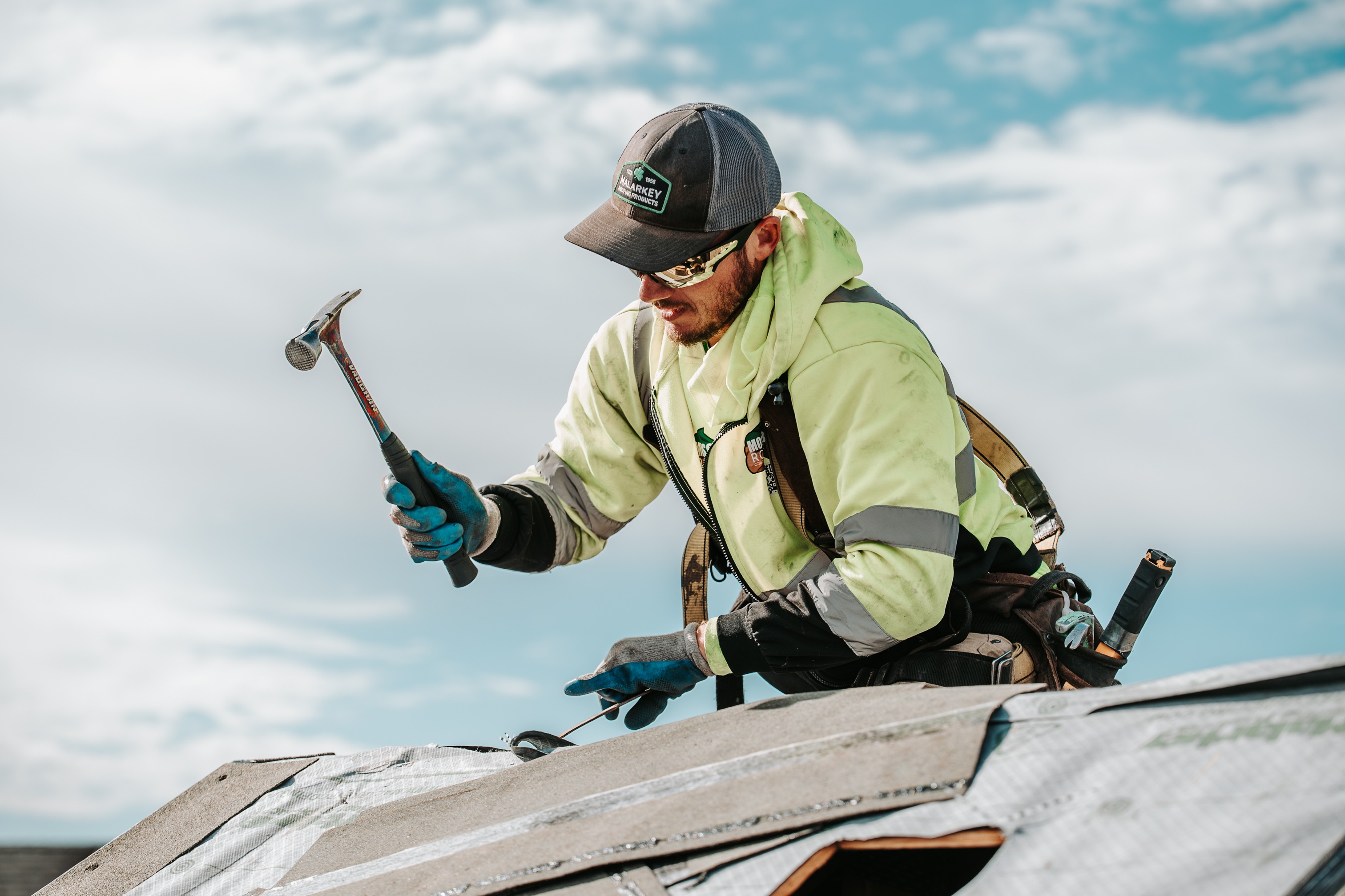 Roofer fastening roofing materials during installation on a residential home. 
