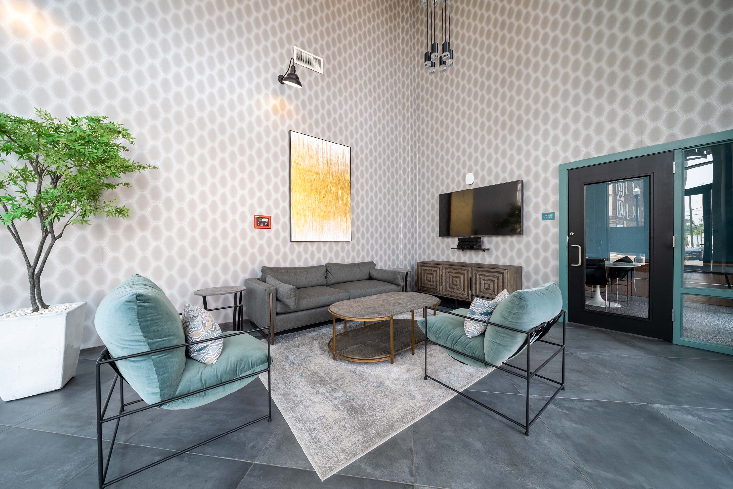 A living room with a grey sofa, a green chair and a television