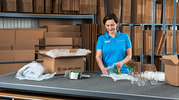 A UPS Store associate packs up a fragile glass vase in preparation to ship