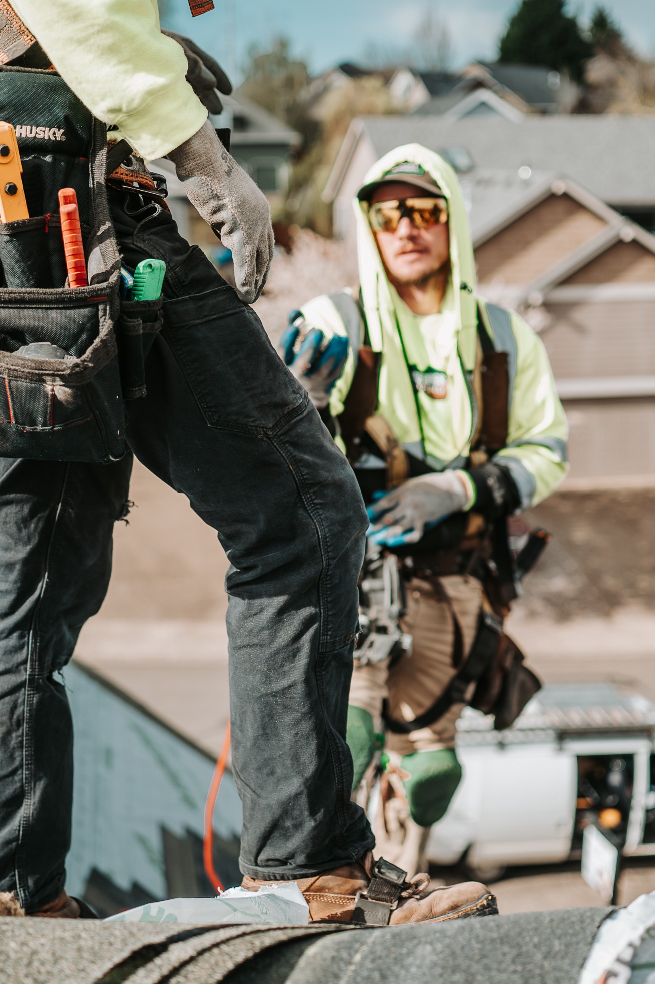 Roofing professionals reviewing materials and installation details during a residential roofing proj 