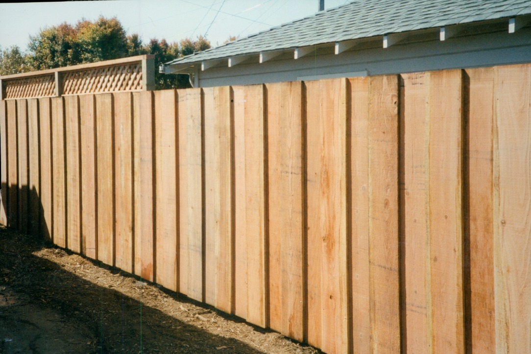 New wood privacy fence installation along a residential property line for added security and outdoor privacy.