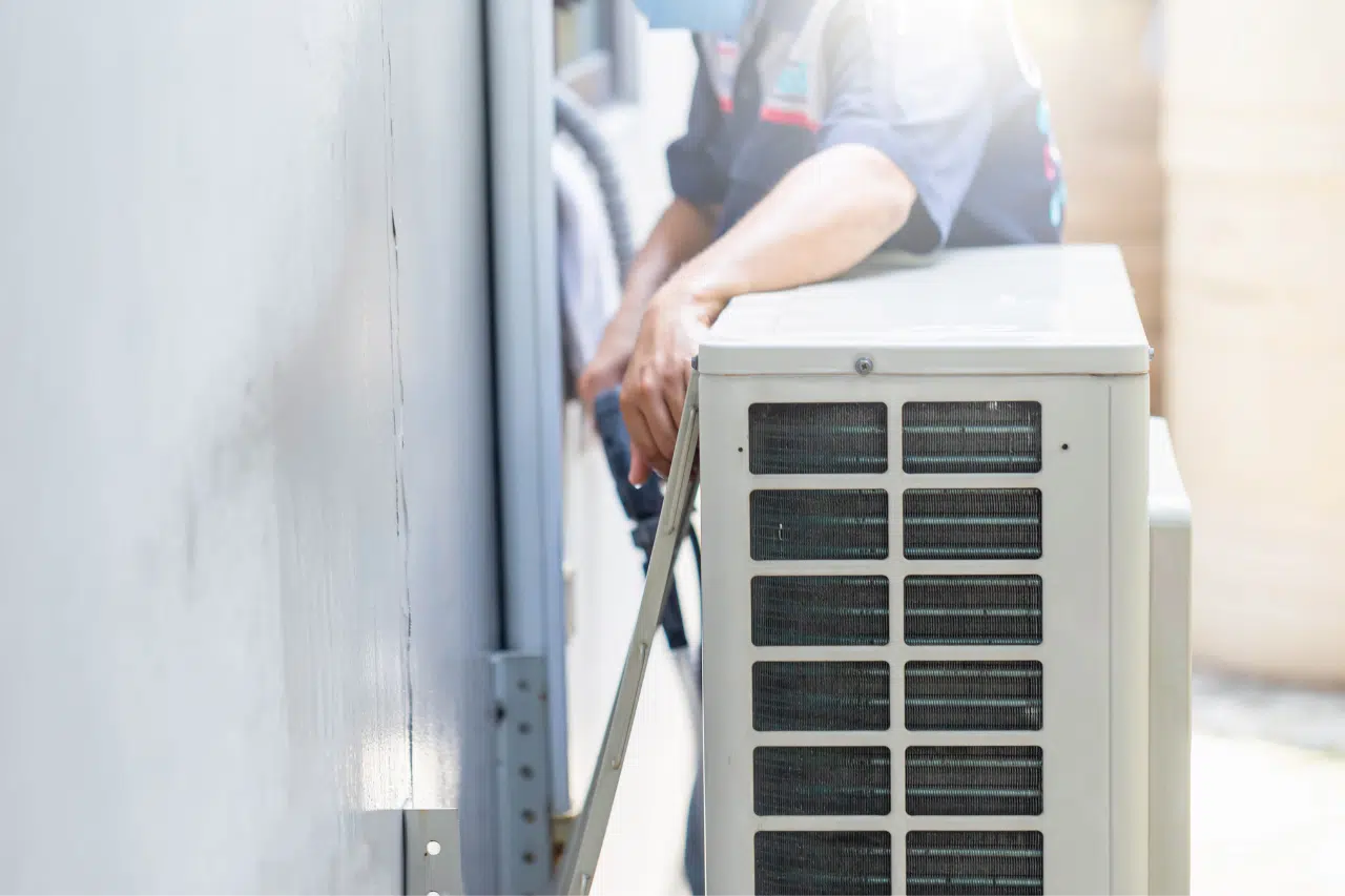 Professional HVAC technician installing and servicing an outdoor air conditioning condenser unit to ensure reliable home cooling. Expert AC installation and maintenance services help improve energy efficiency, extend equipment lifespan, and maintain consistent indoor comfort.