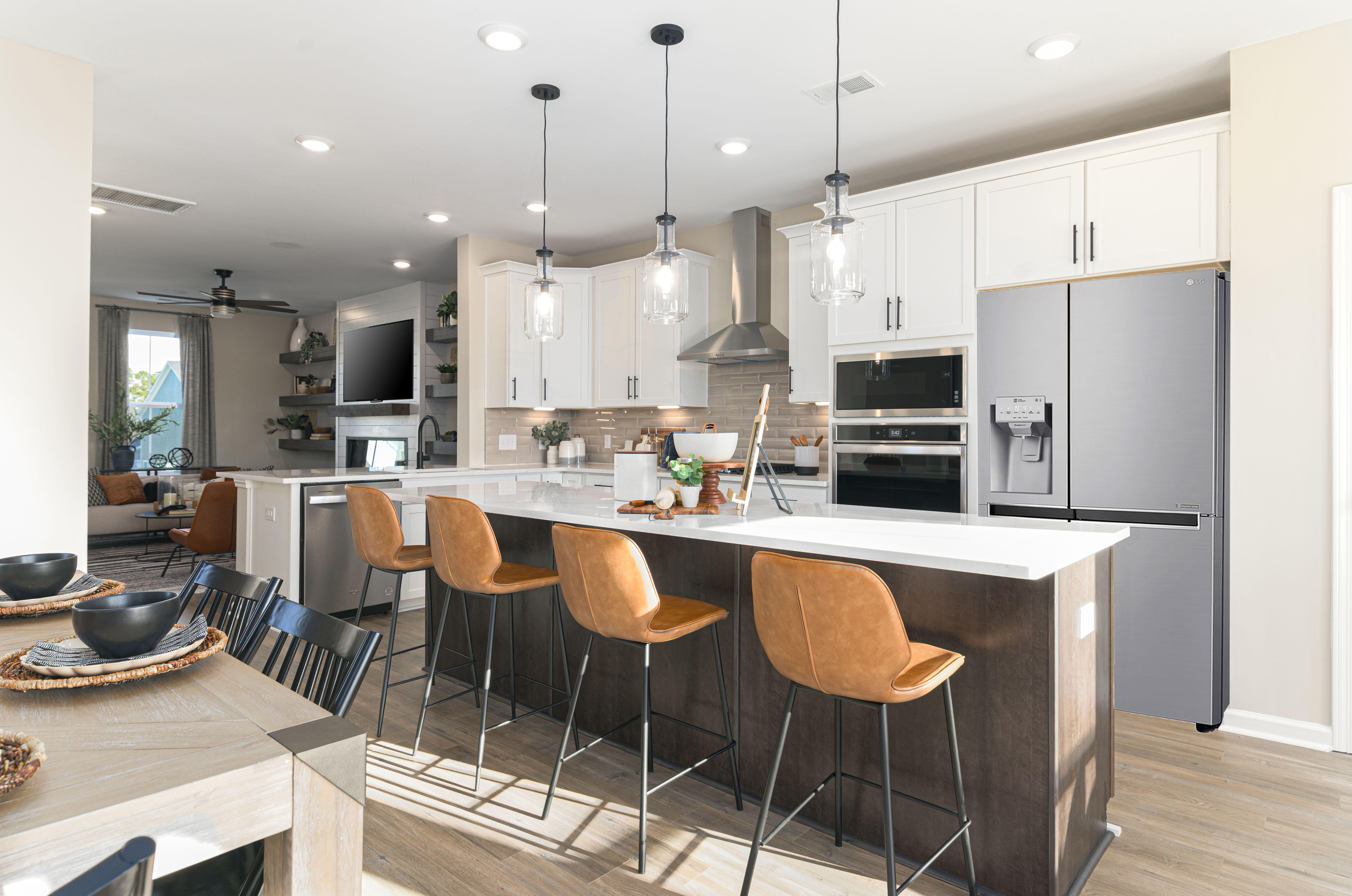 Gourmet kitchen with white cabinets, wood tone island and stainless steel appliances in the DRB Homes Recess Pointe community