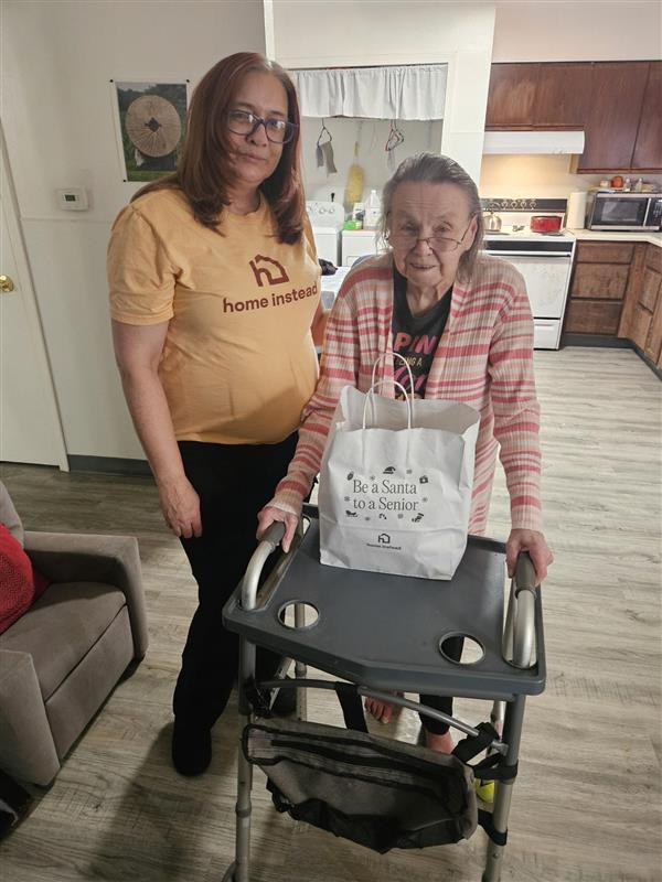 Home Instead caregiver delivering Be a Santa to a Senior gifts to support and connect with older adults.