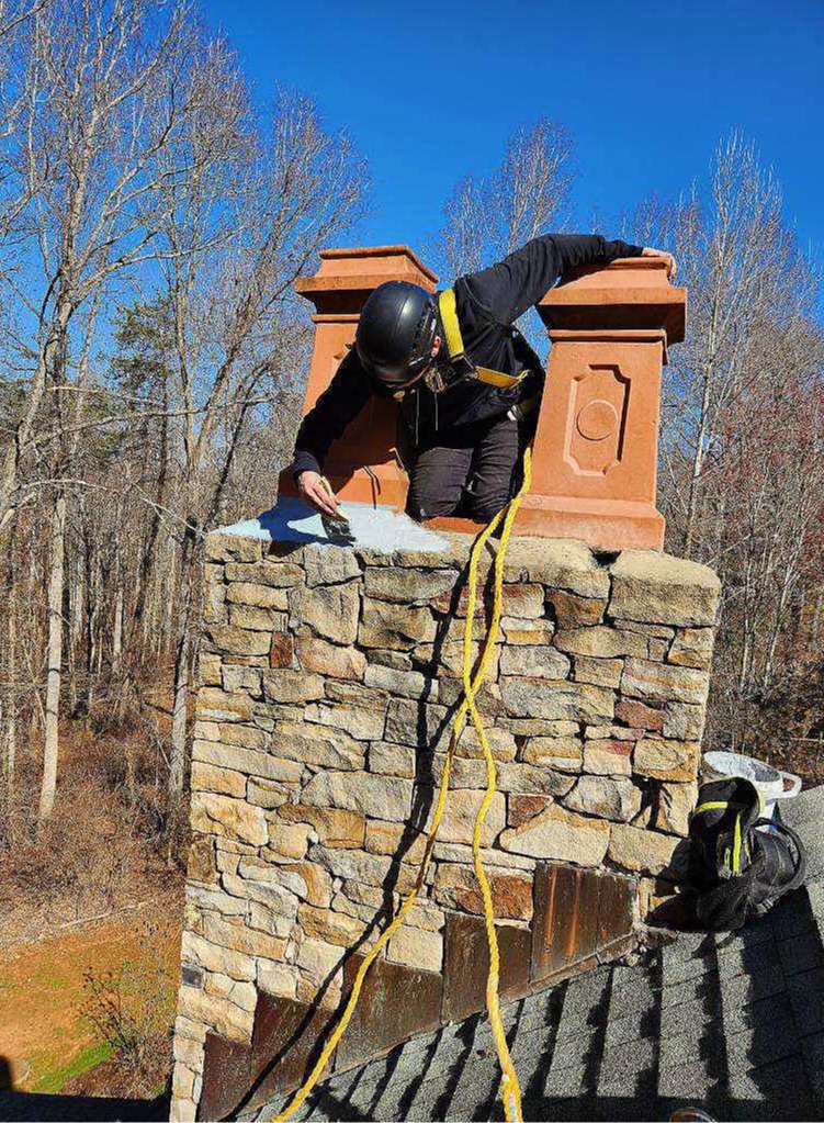 Flue Pros Chimney technician performing masonry chimney crown repair on a home in Lynchburg, VA.