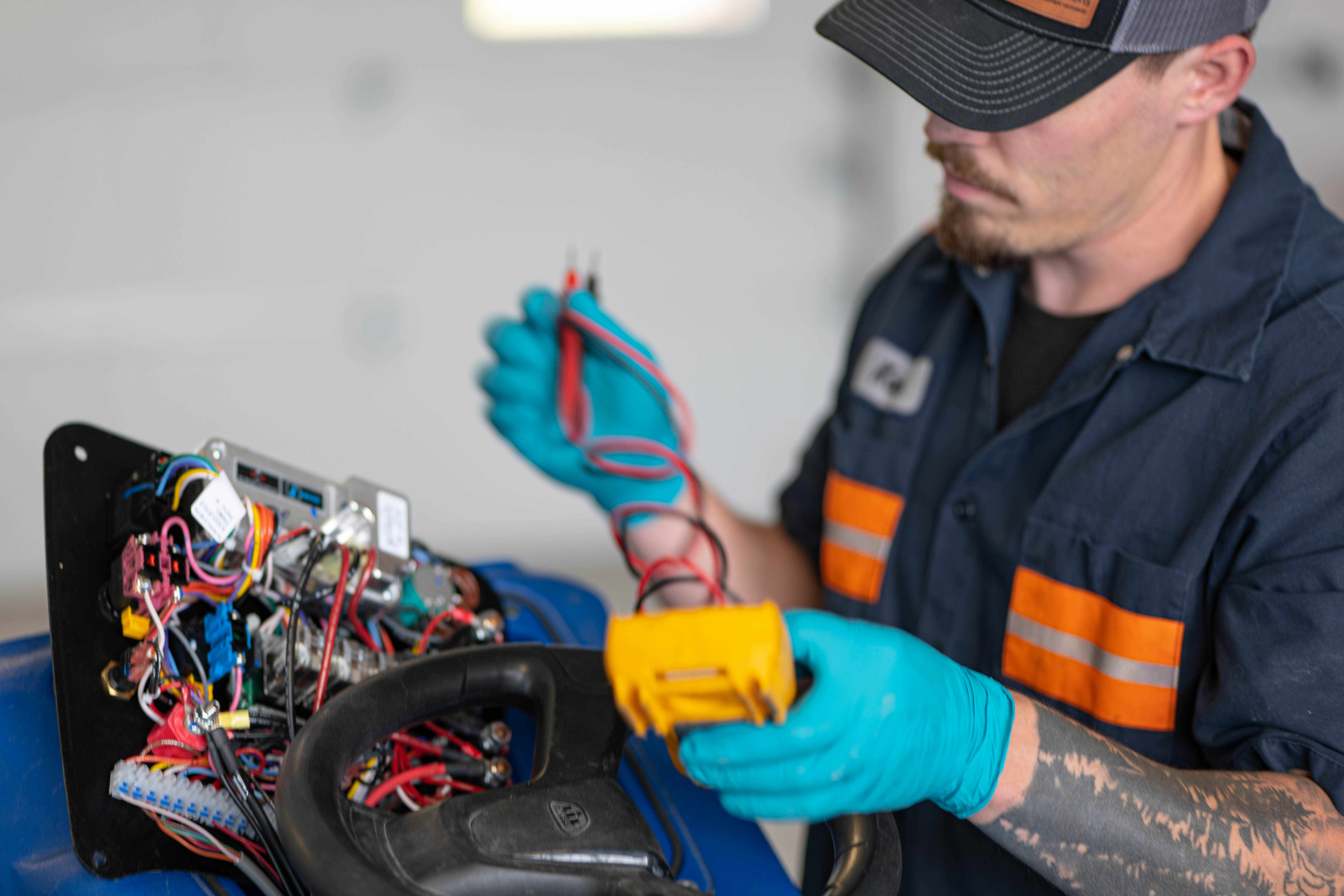 A certified WaySolutions technician performs deep electrical maintenance and component repairs on an Advance ride-on commercial floor scrubber. Using precision power tools and diagnostic meters within the battery compartment, our Layton, Utah mechanics ensure high-capacity cleaning equipment maintains maximum power and runtime.