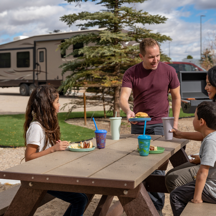 Family enjoying lunch at a private picnic table at Little America's RV Park.