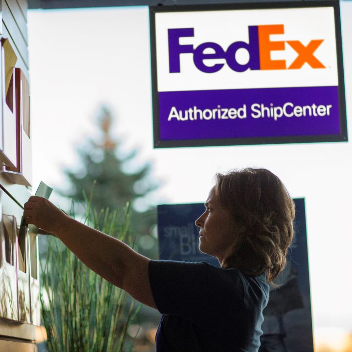 A woman grabbing shipping supplied from wall with FedEx Authorized ShipCenter sign in the background FedEx Authorized ShipCenter Fort Walton Beach (251)753-8221