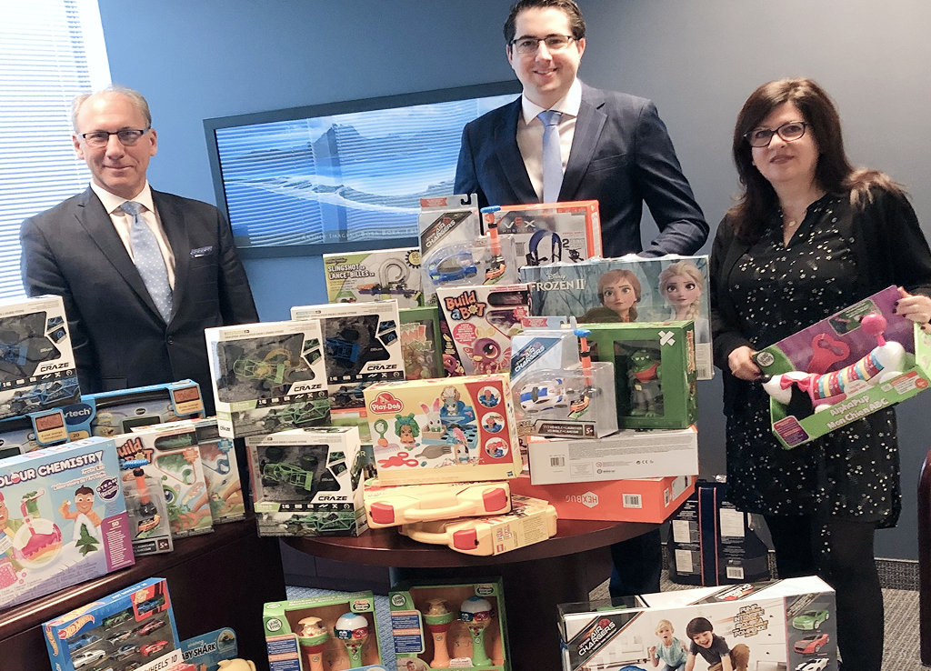 The Arnautovich team standing with a large collection of toys they donated.