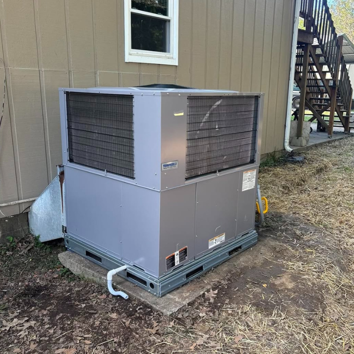 Gas-electric package unit set on a concrete pad at a Southern Illinois home.