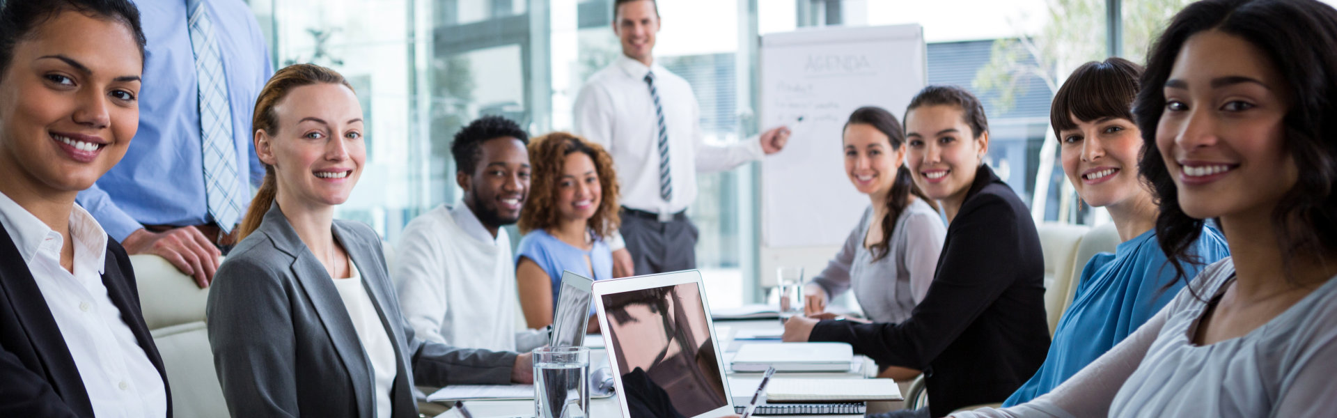A group of diverse professionals, including men and women, are seated around a conference table, smi 