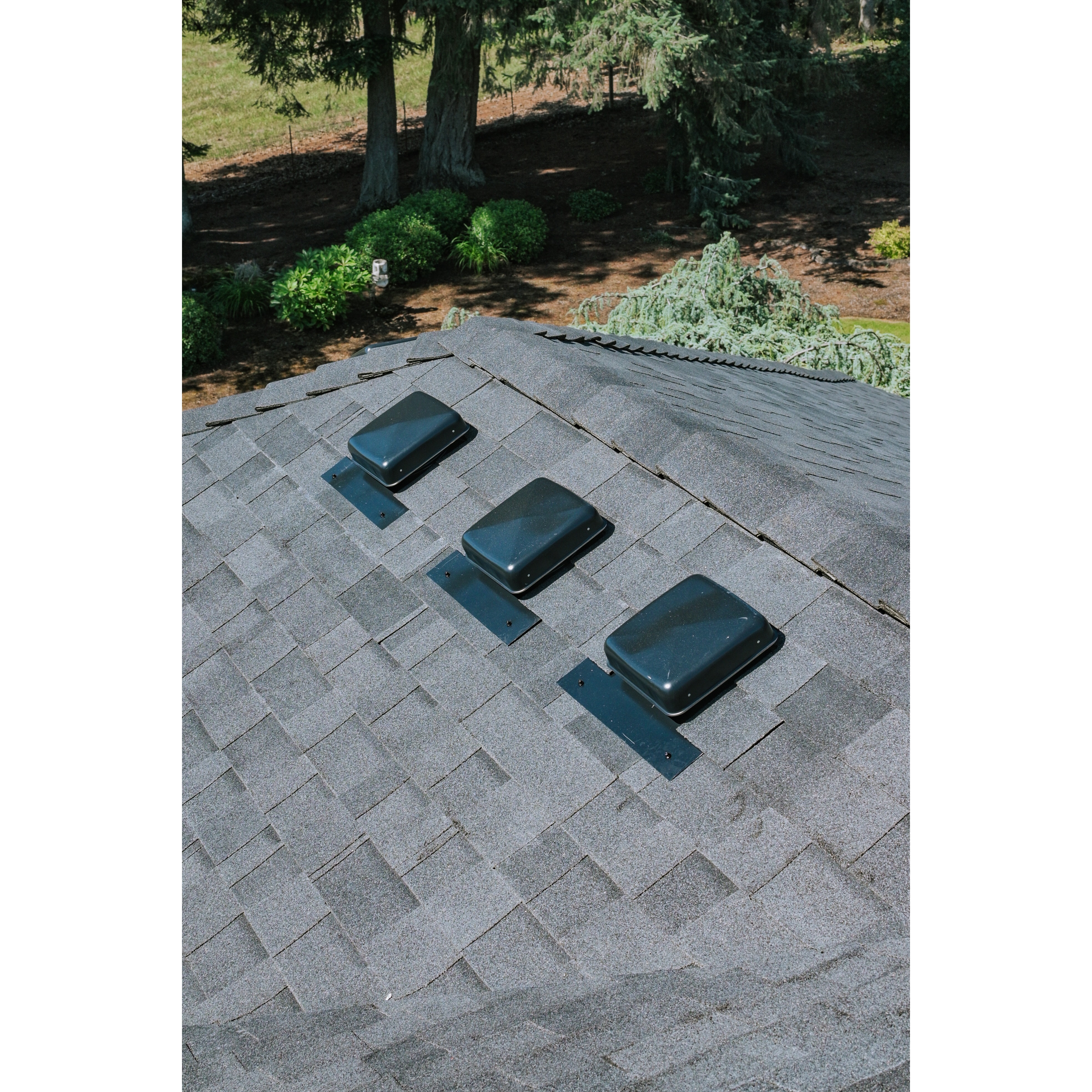 View of roof vents and surrounding asphalt shingles on a completed residential roofing system. 