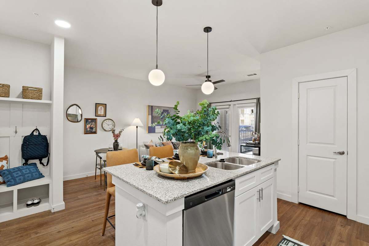A kitchen with a white counter and a plant on it. 
